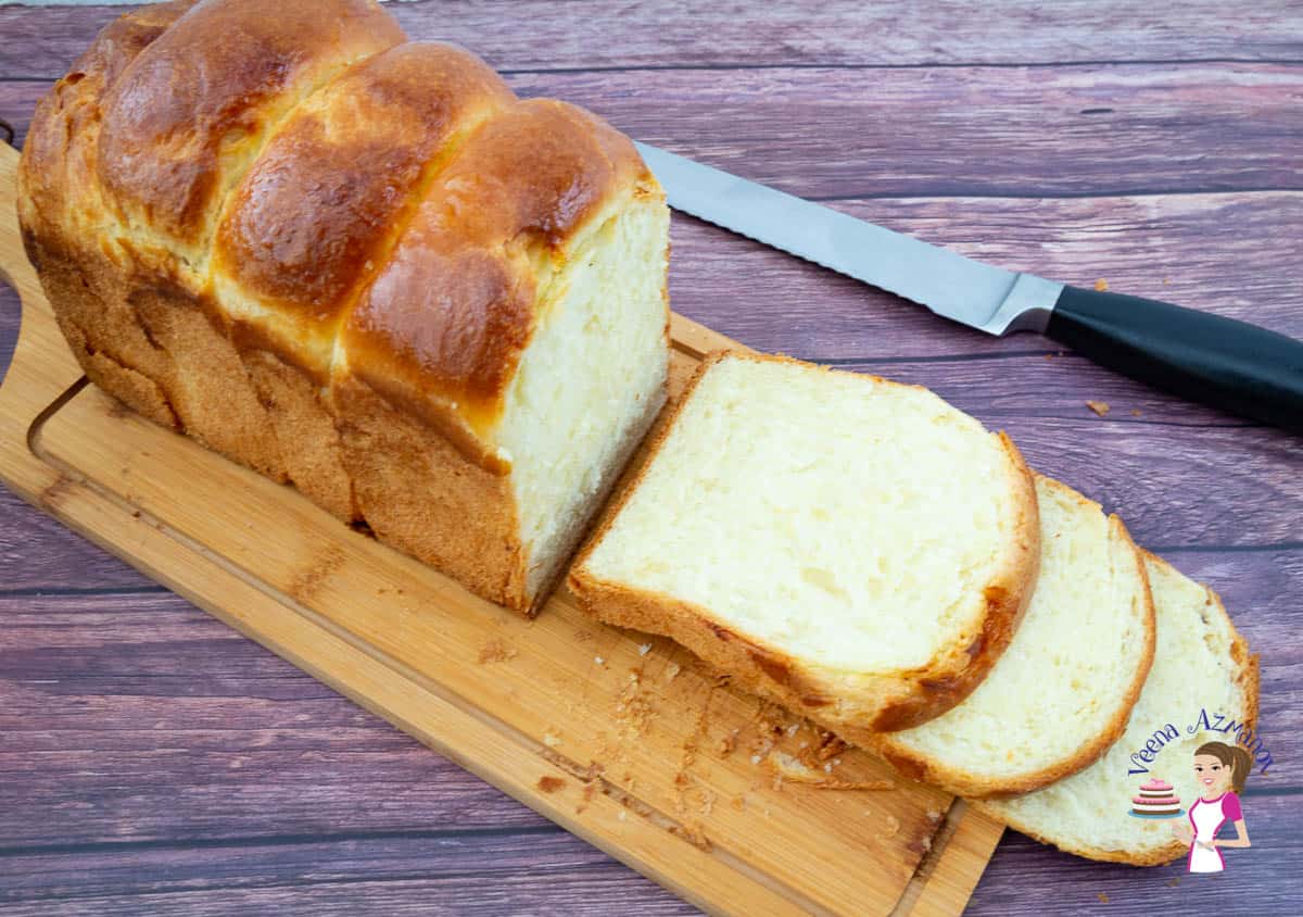 A sliced loaf of sandwich bread on a wooden cutting board.