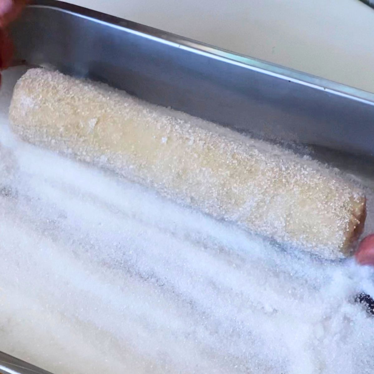 Roll the cookie dough log with granulated sugar.