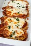 Pieces of chicken Parmesan in a serving dish.