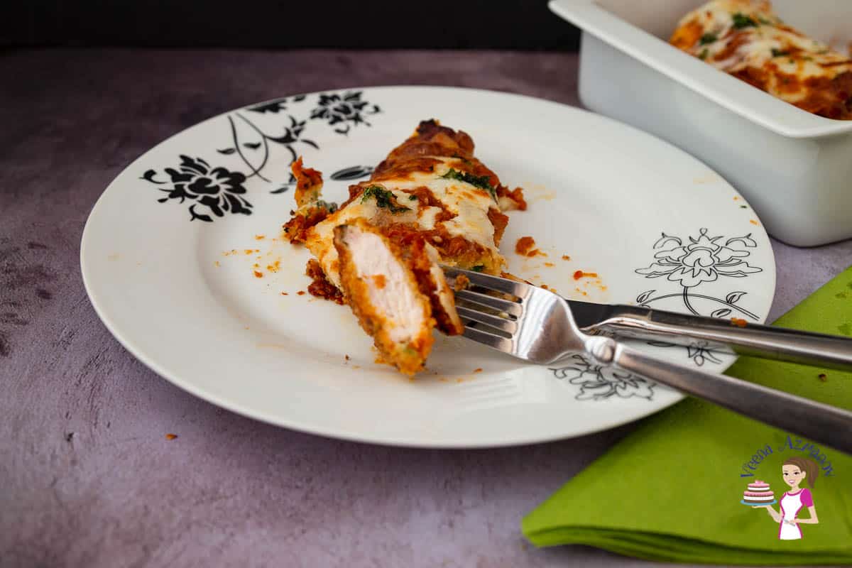 A plate a cut piece of chicken Parmesan.