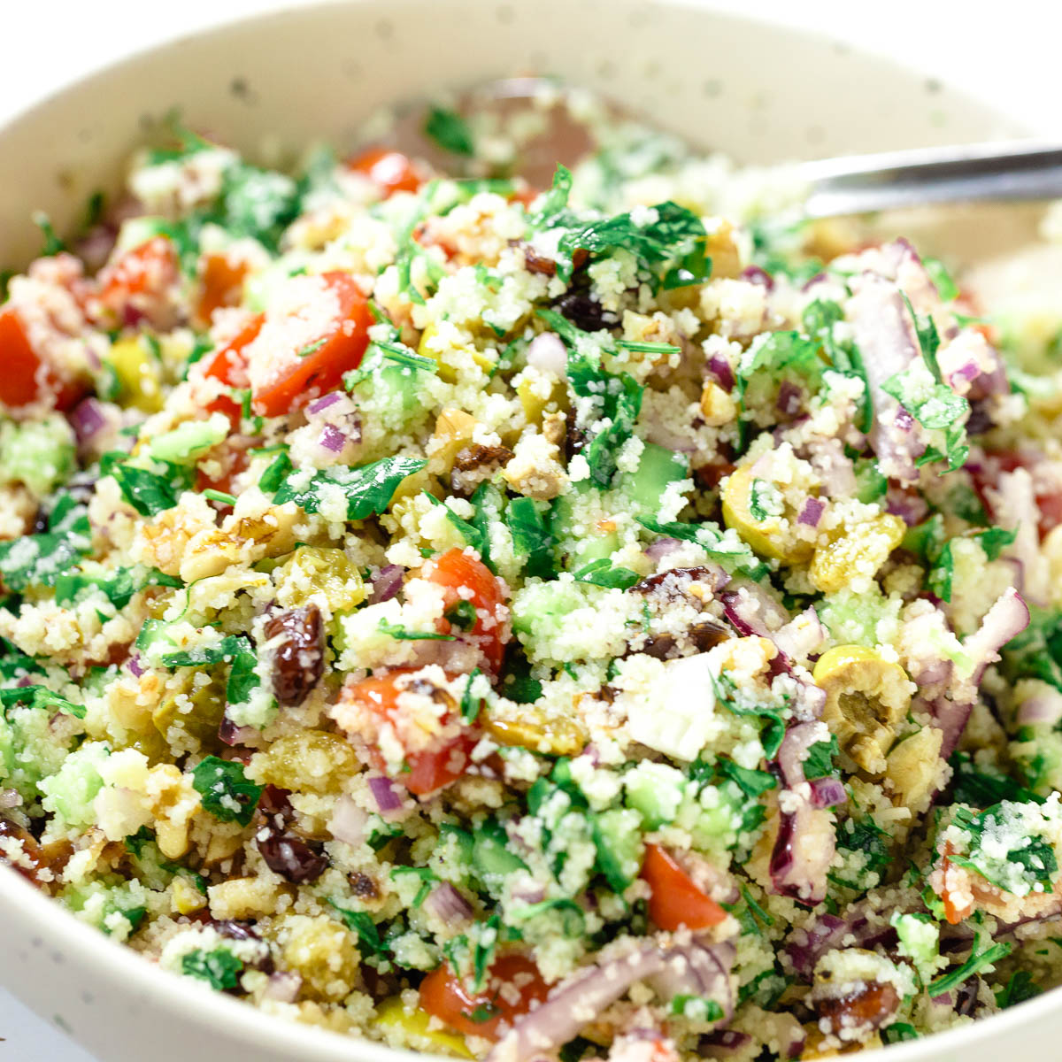 A bowl with couscous salad and dressing.