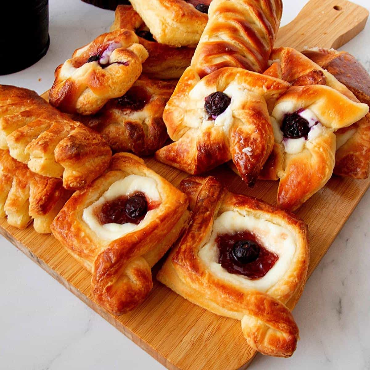 Danish pastries on a wooden board.
