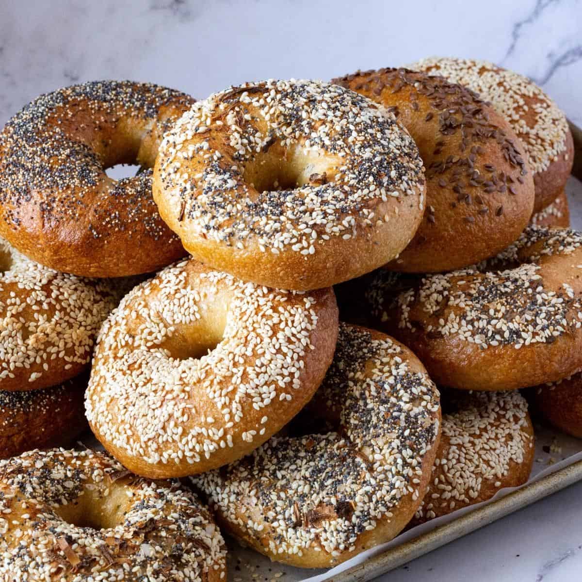 A baking tray with a stack of bagels.