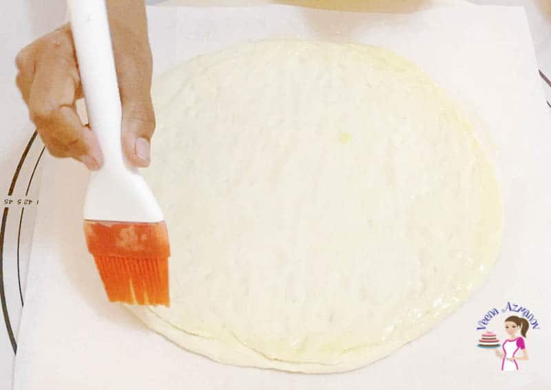 Brush the edges of the pizza with oil