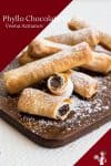 A stack of filo cigars filled with chocolate on a wooden tray.