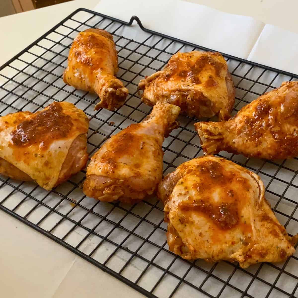 A wire rack with chicken for baking.