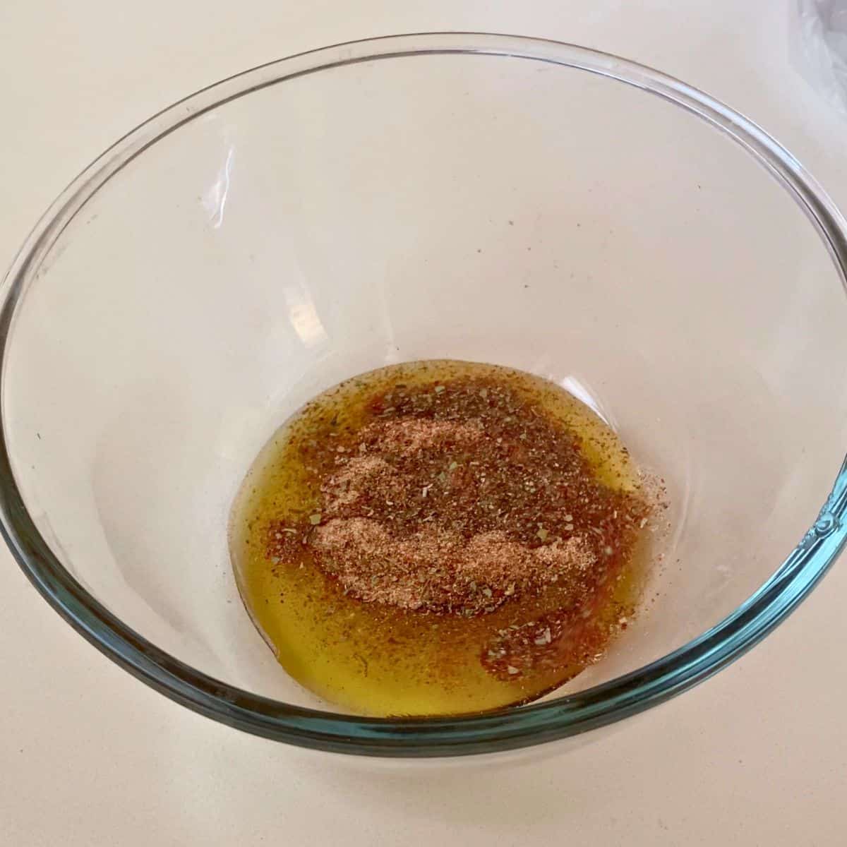 A glass bowl with cajun marinade.