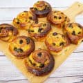 Danish pastry spirals with raisins on a wooden tray.
