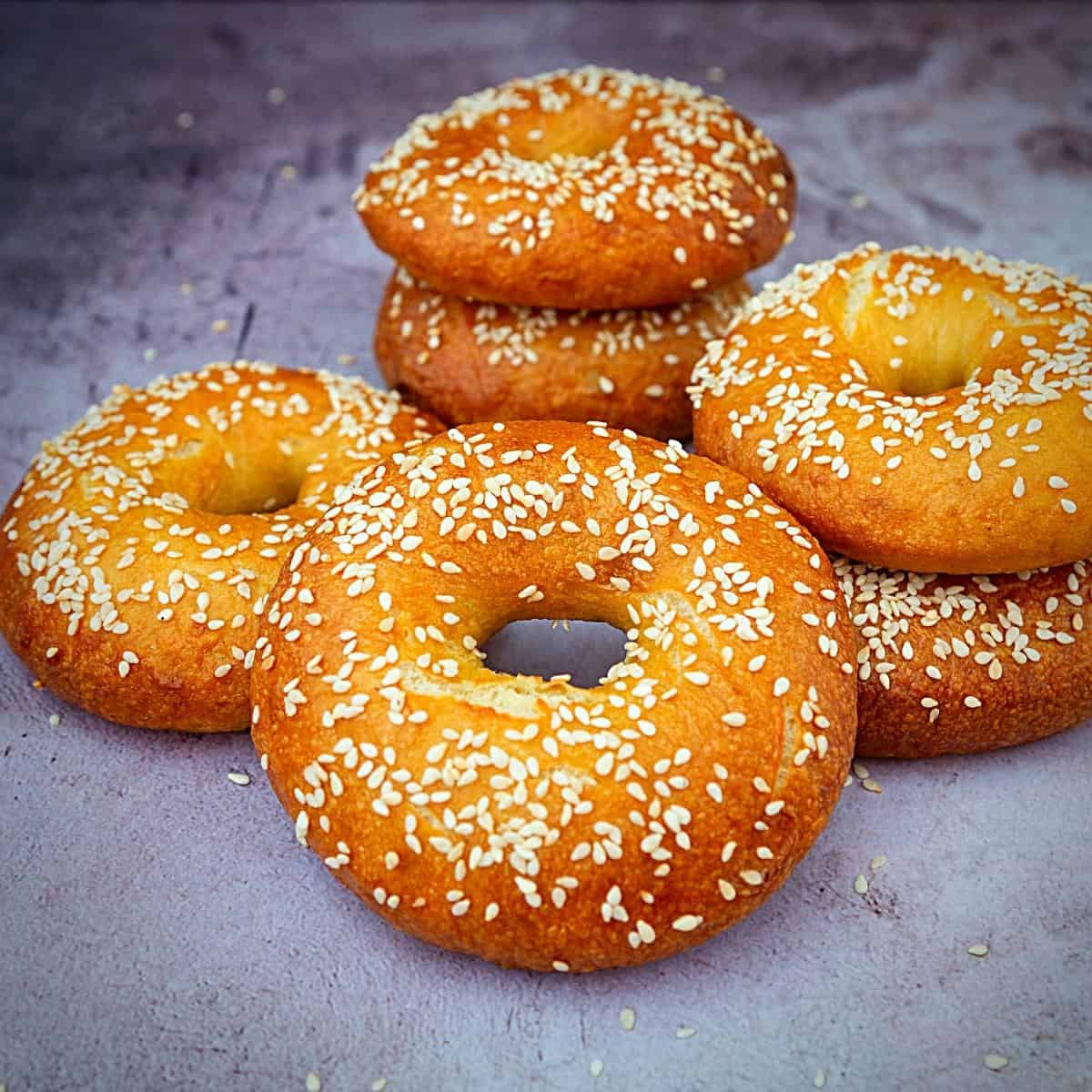 Bagels on a table topped with sesame seeds.