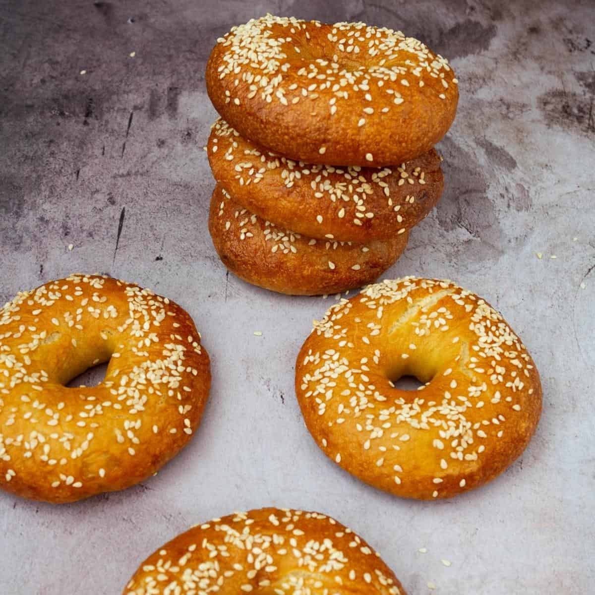 Bagels on a table topped with sesame seeds.