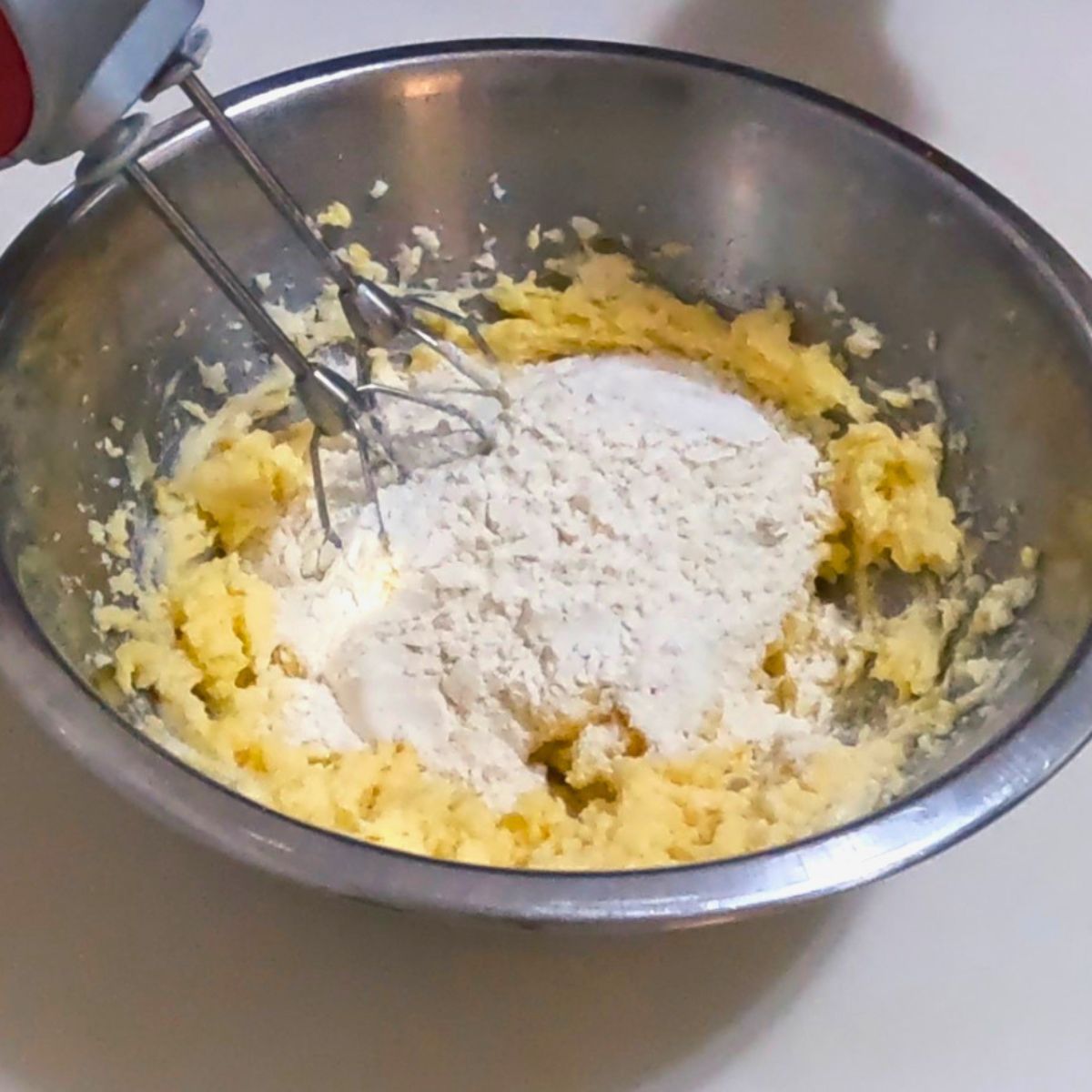 Adding flour to the cookie dough.