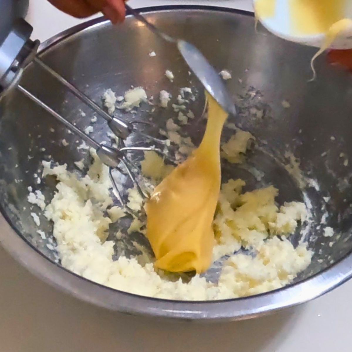 Adding condensed milk to the cookie dough batter.