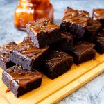 Stack of caramel brownies on the wooden board.