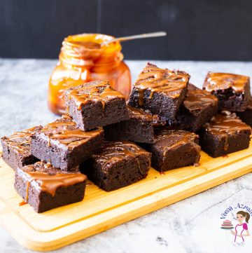 A stack of caramel brownies on a wooden tray.