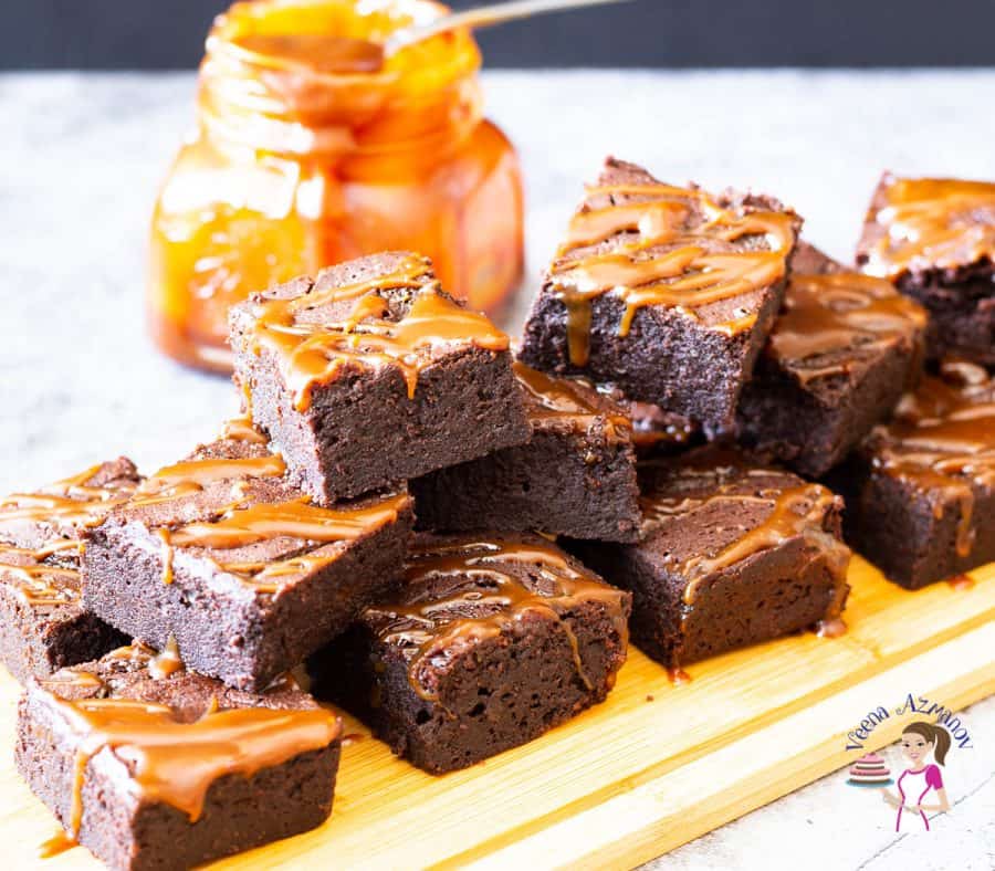 A stack of caramel brownies on a wooden tray.