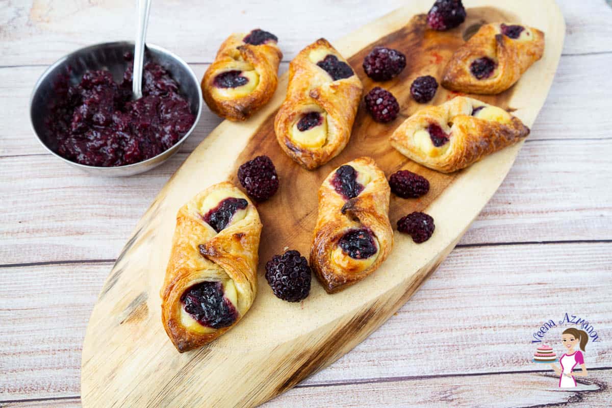 Danish pastry with berries on a wooden tray.