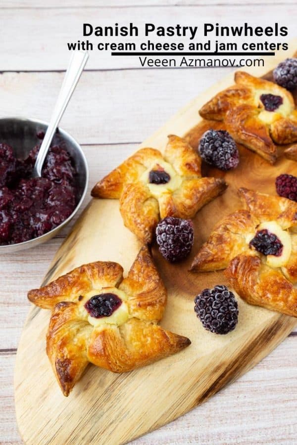 Danish pastries with berries on a wooden board.