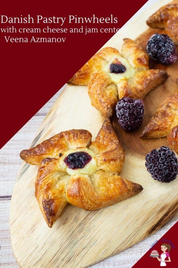 Danish pastries with berries on a wooden tray.
