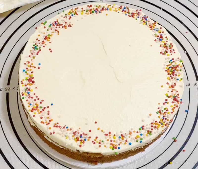A top view of a funfetti cake on a cake stand.