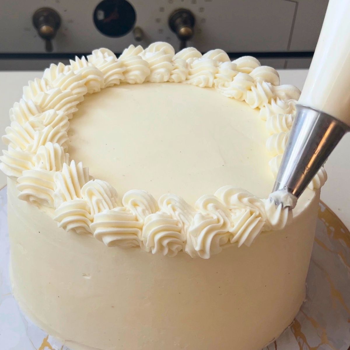Piping frosting on the funfetti cake.