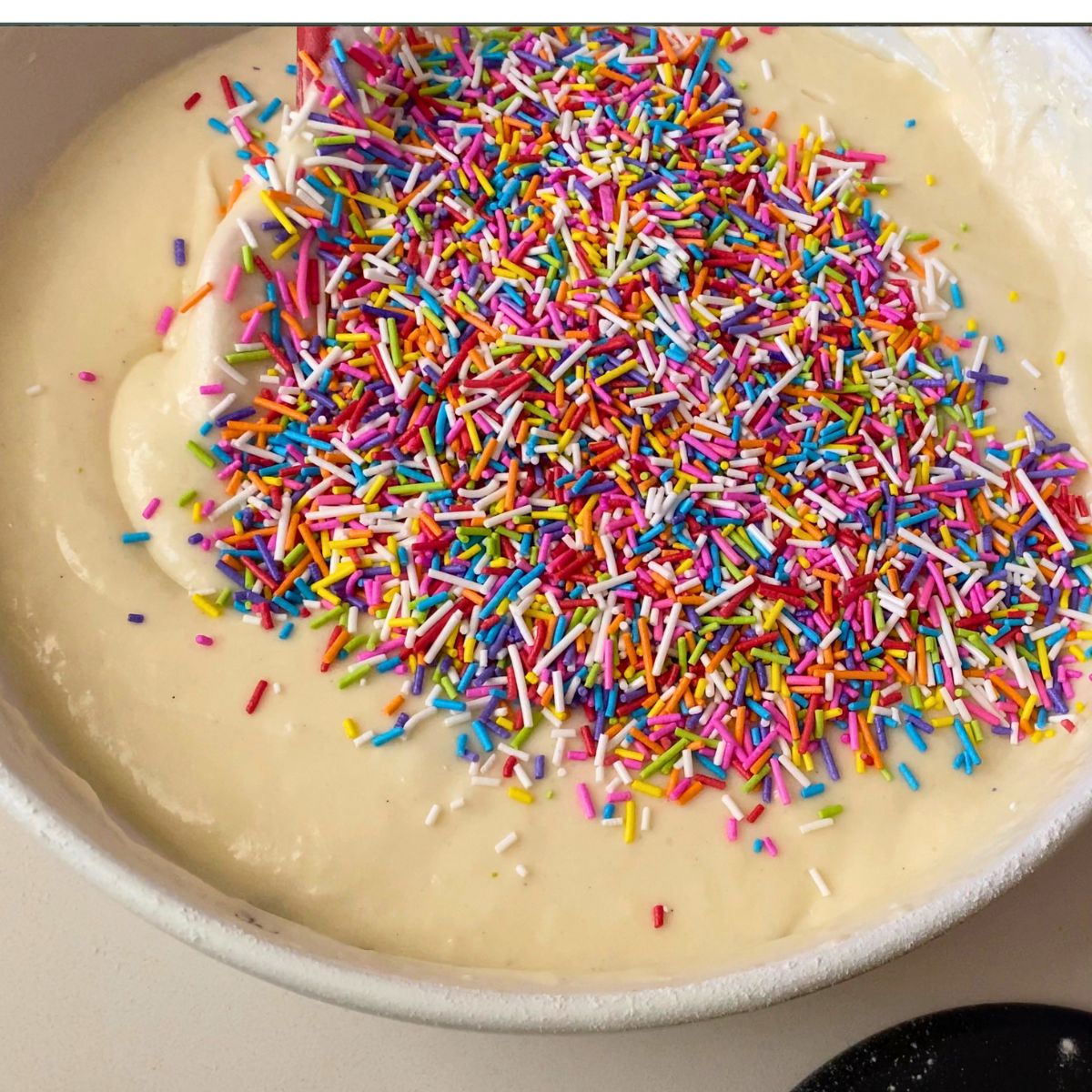 Adding rainbow jammies to the cake batter.
