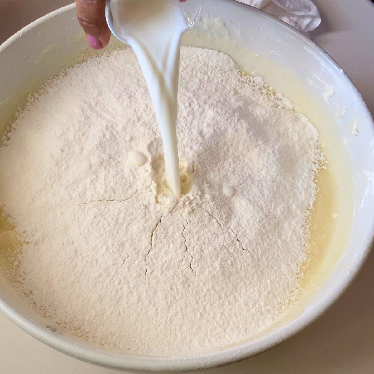 Adding flour and buttermilk to the cake batter.