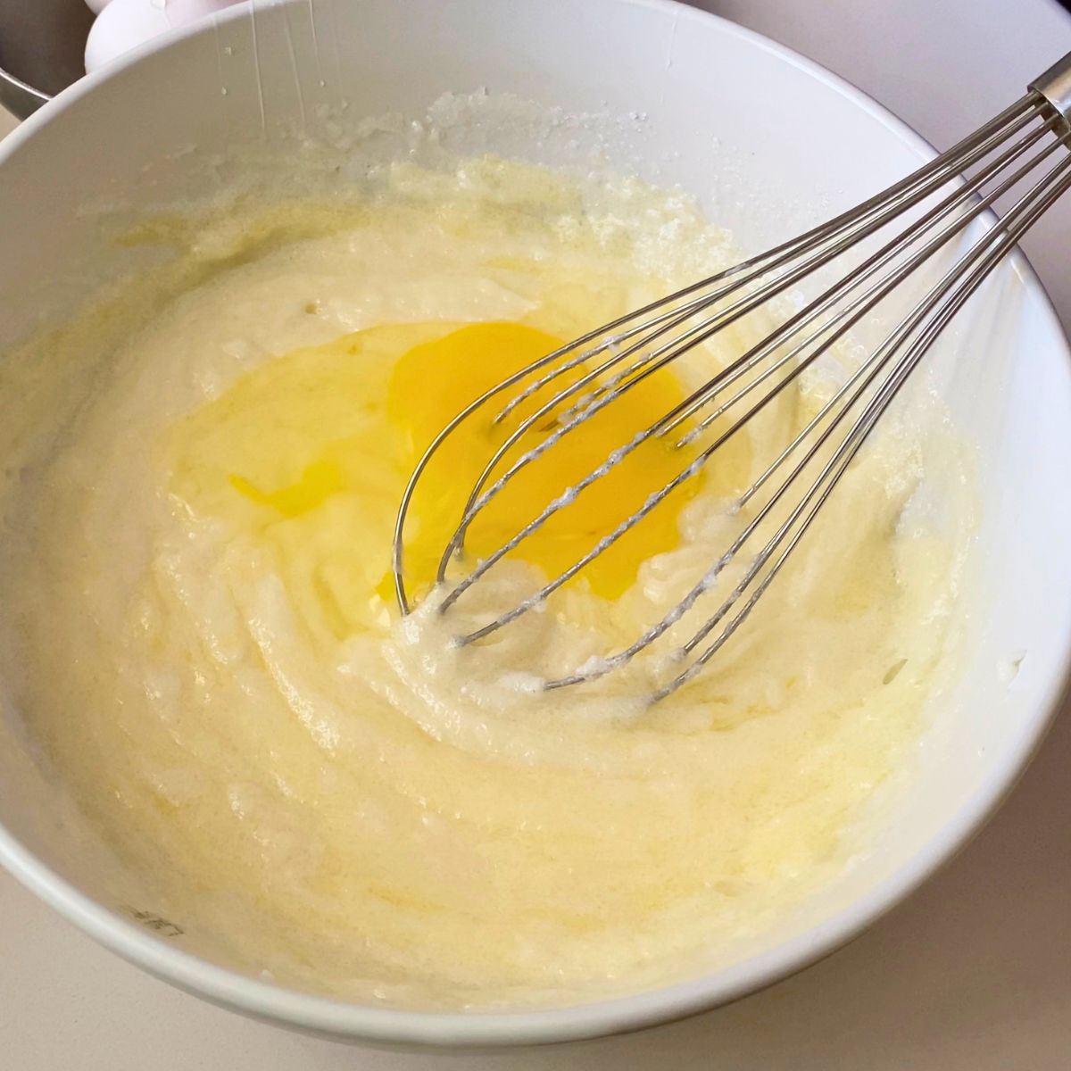 Adding eggs to the cake batter.