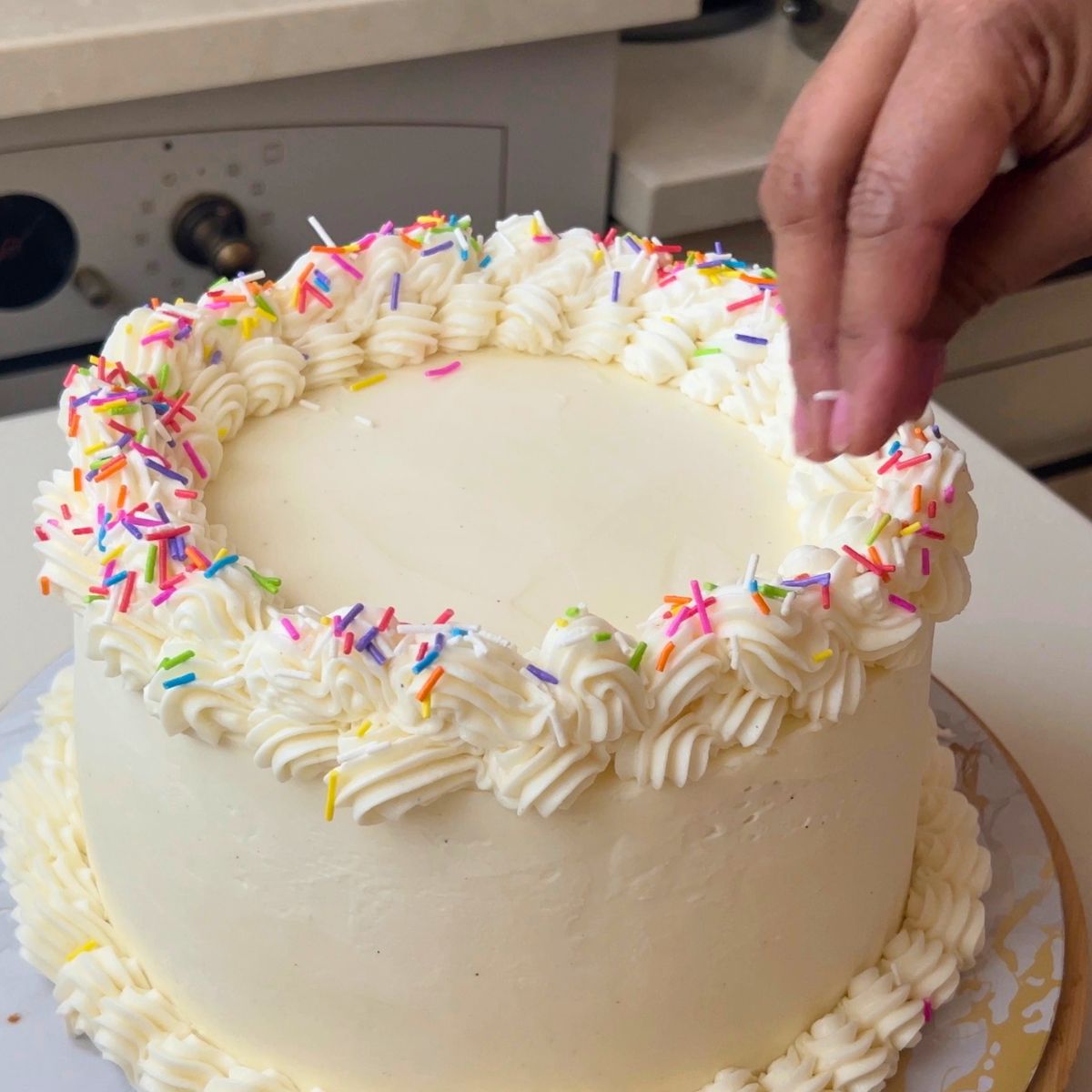 Adding sprinkles to the funfetti birthday cake.
