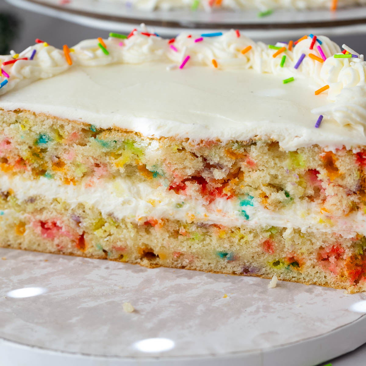 Sliced funfetti cake on the cake board.