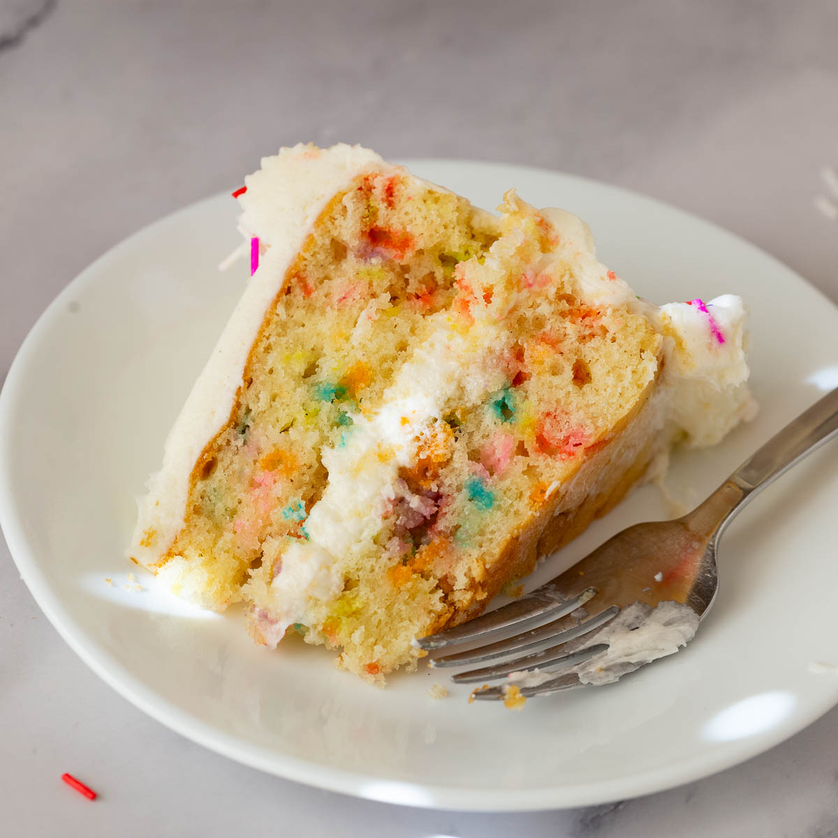 A slice of funfetti cake on the plate.
