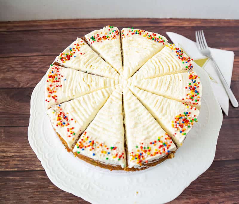 A top view of a sliced funfetti cake on a cake stand.