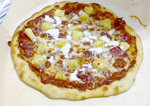 Bake the pizza with pineapple, ham and cheese