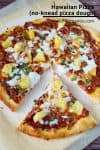 Sliced pineapple pizza on a wooden tray.