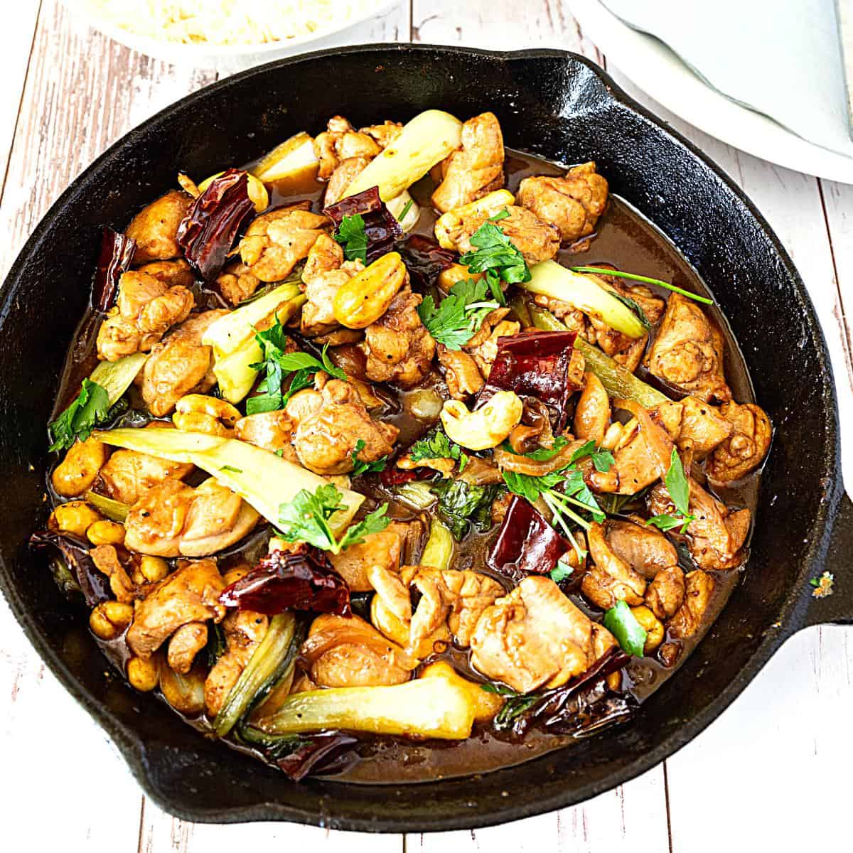 A skillet with chicken and kung pao.