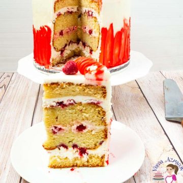 A slice of raspberry cake with white chocolate frosting.