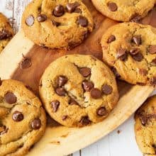 Soft and chewy chocolate chip cookies on a wooden board.