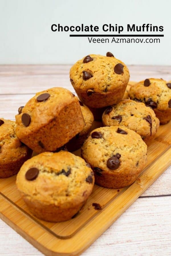 A stack of chocolate chip muffins on a wooden board.