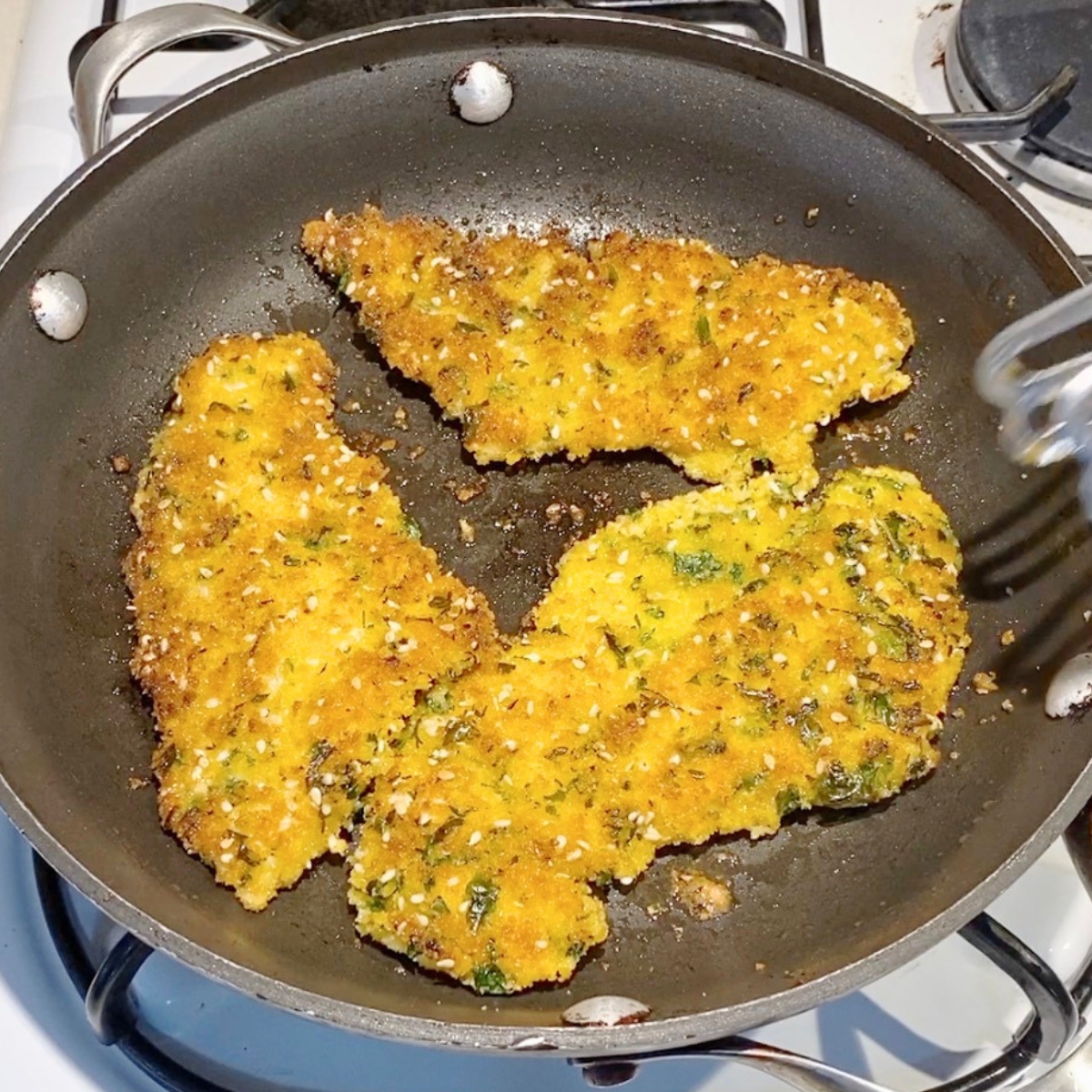 A skillet with pan fried chicken breast.