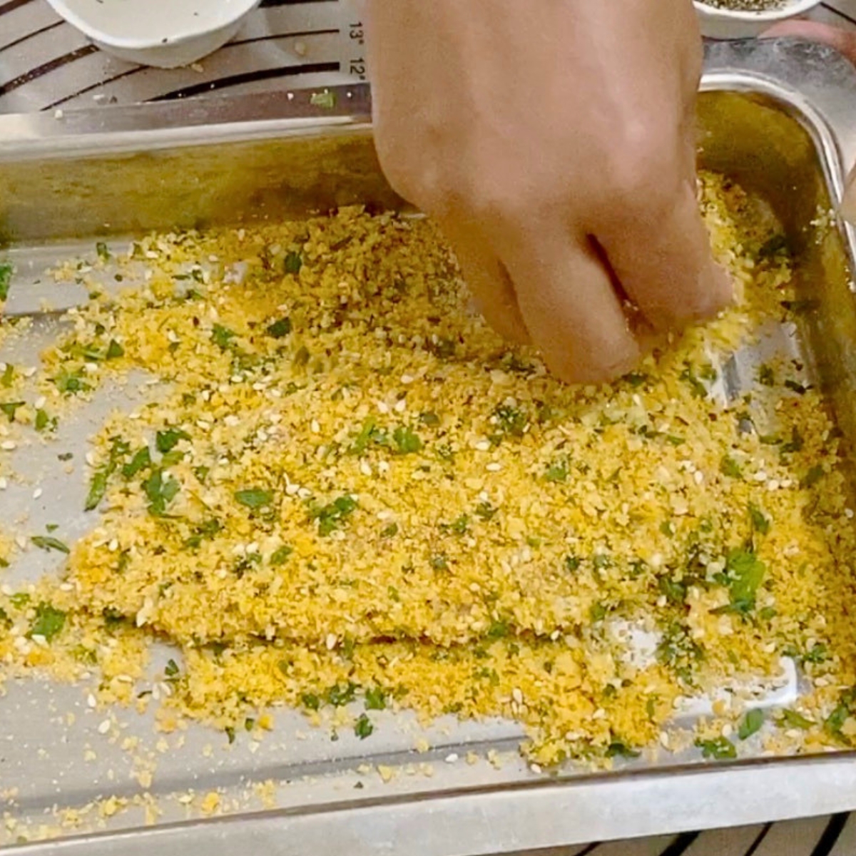 Coating the chicken breast in breadcrumb mixture.