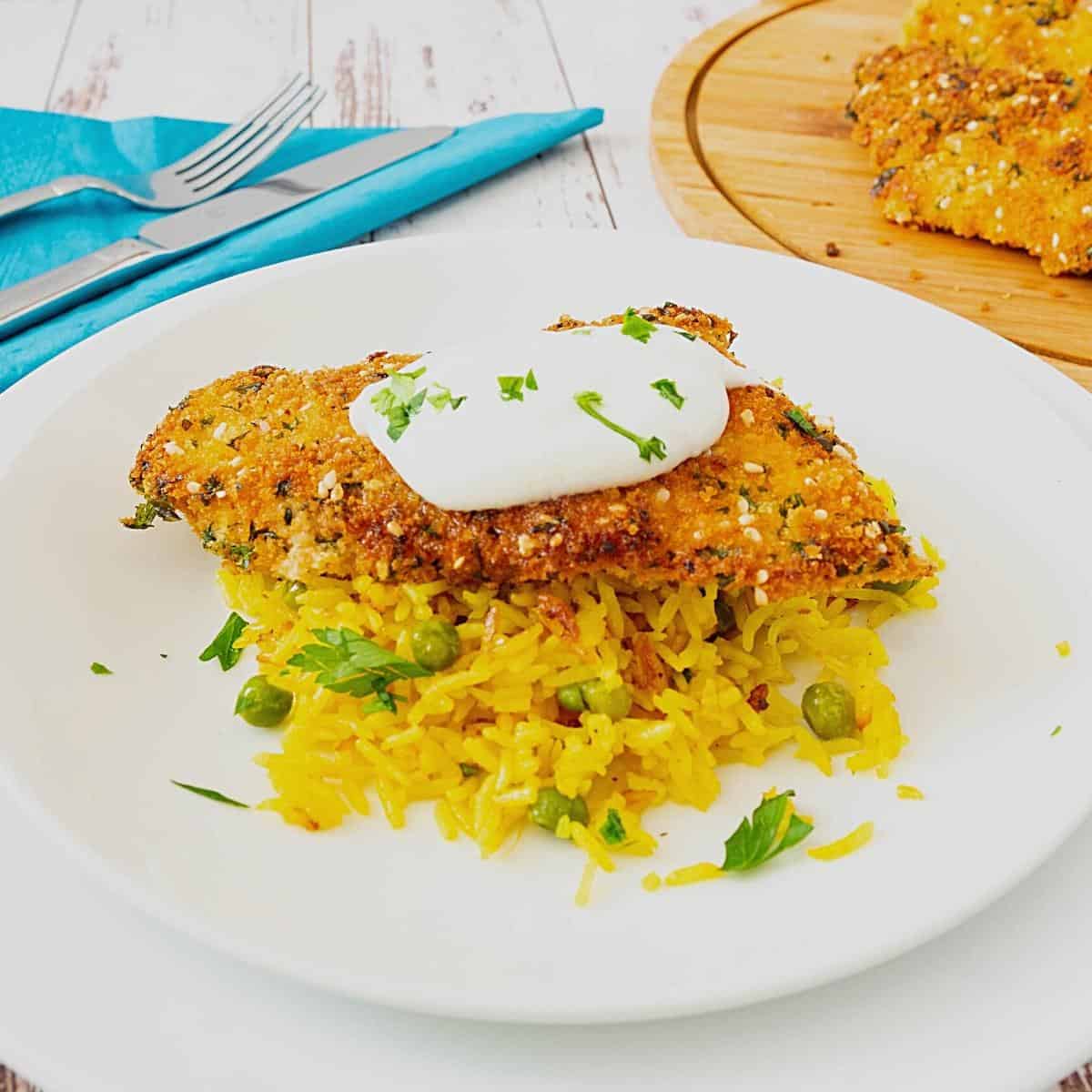 Turmeric rice topped with breaded chicken.