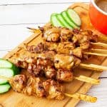 Satay skewers on a wooden board.