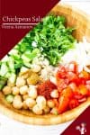 A wooden bowl with chickpeas, cucumbers and Tomato salad.