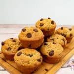 a stack of chocolate chip muffins on a wooden board