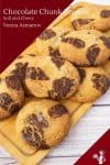 A stack of chocolate chunk cookies on a wooden board.