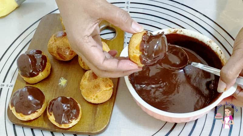 Dip each cream puff in the chocolate glaze