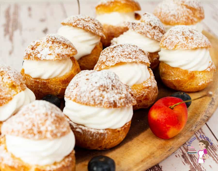 Cream puffs on a wooden tray.