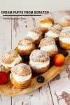 several cream puffs arranged on a wooden tray.