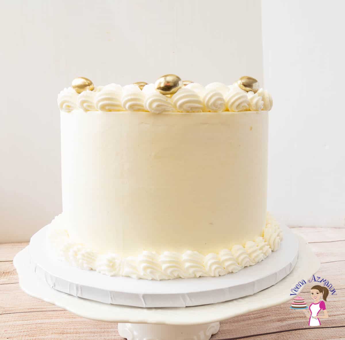 A white wedding cake on a cake stand.