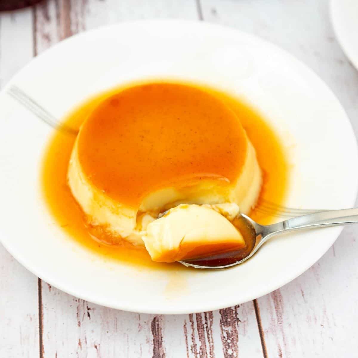 A spoon and plate with flan.