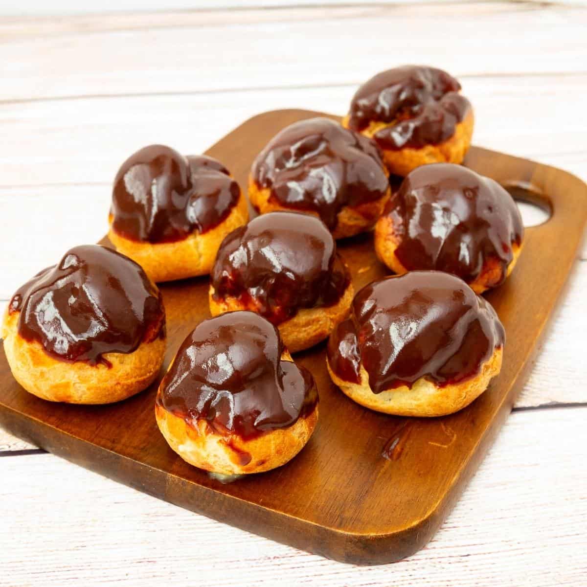 A wooden board with profiteroles.